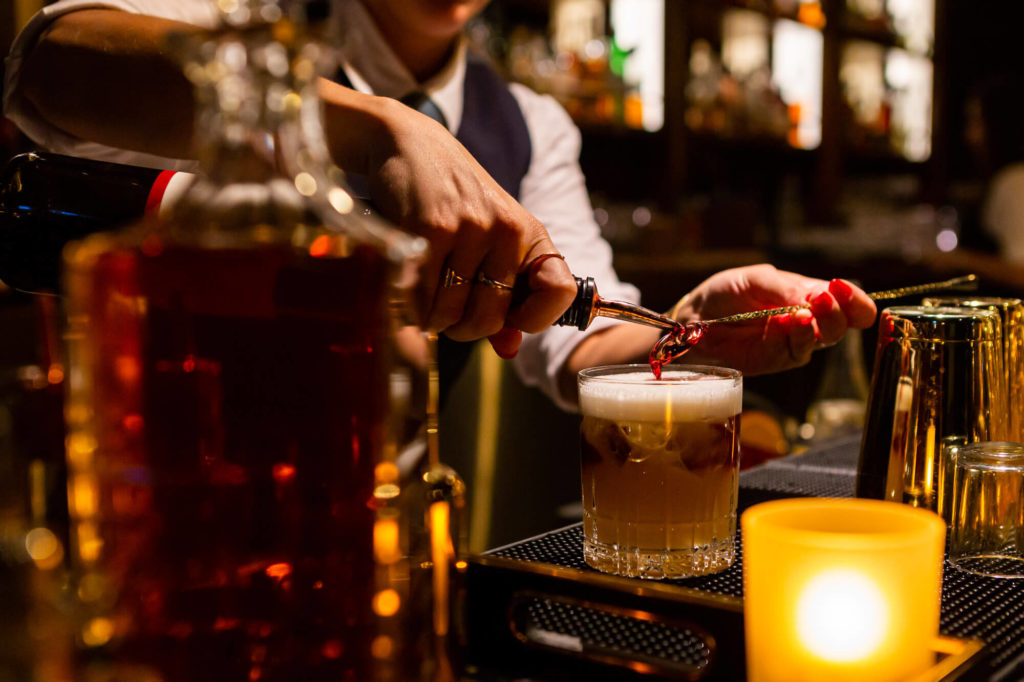 Bartender pouring a cocktail at the Canoe bar.