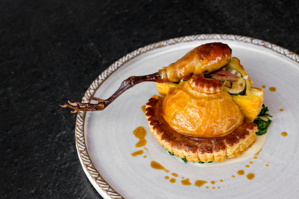 Ontario pigeon pithivier, Québec foie gras, collard greens, James Bay matsutake, red currant jus