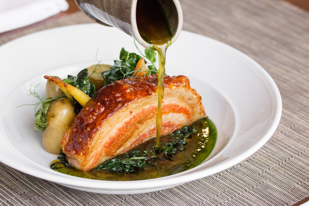 Summerlicious pork dish at Canoe in downtown Toronto served on white plate on gray table
